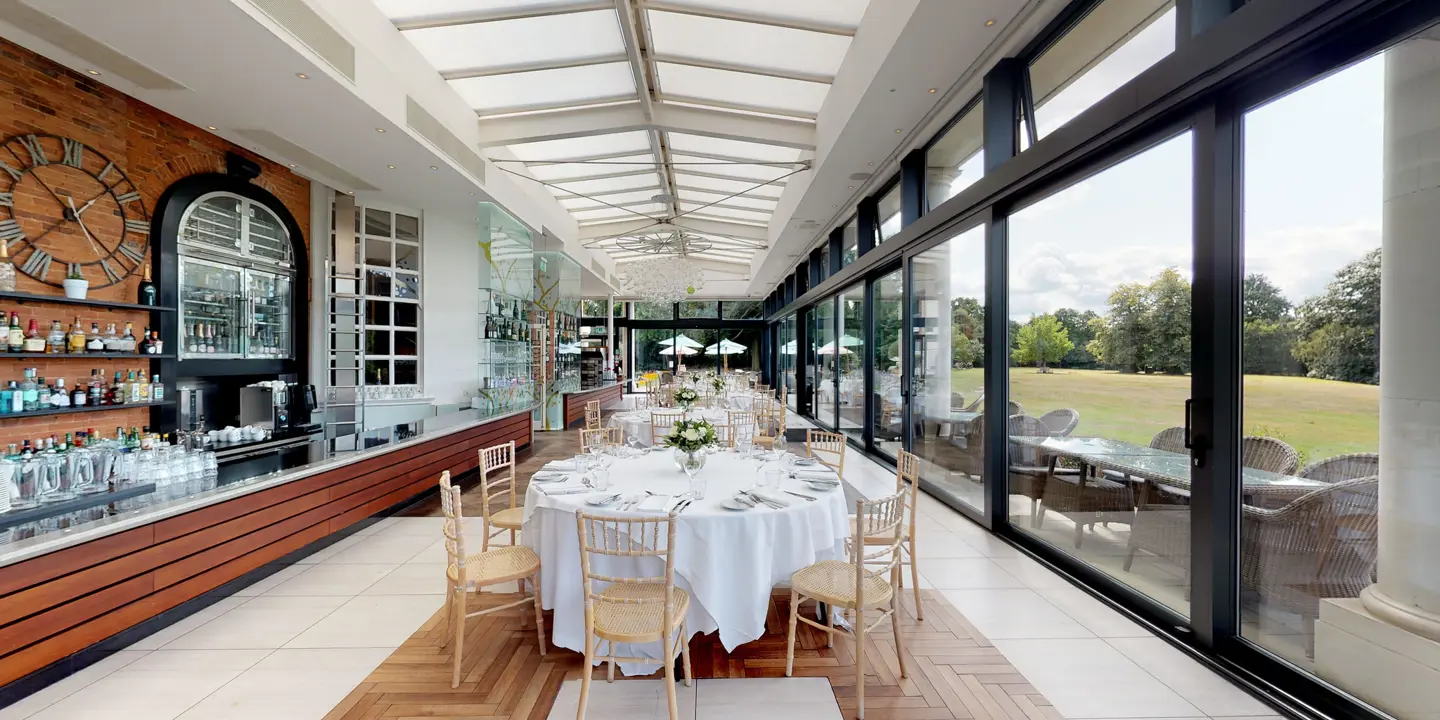 A spacious dining room furnished with elegant round tables and chairs.