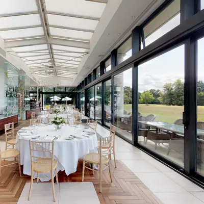 A spacious dining room furnished with elegant round tables and chairs.