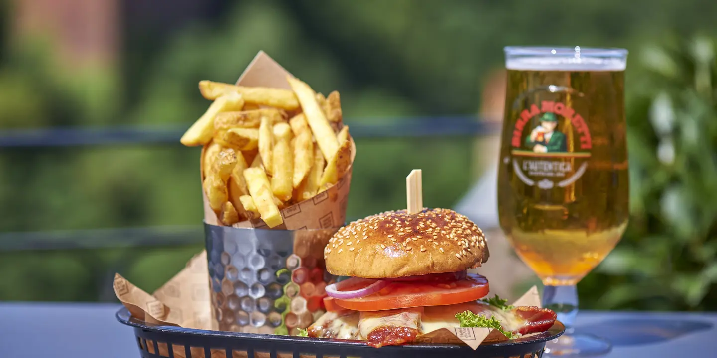 A table with a basket of food and a glass of beer.