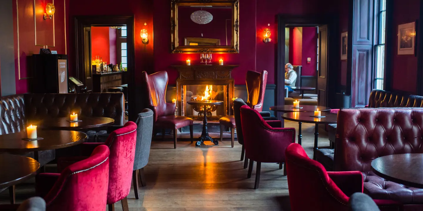 An elegantly furnished room featuring a centrally positioned fireplace.