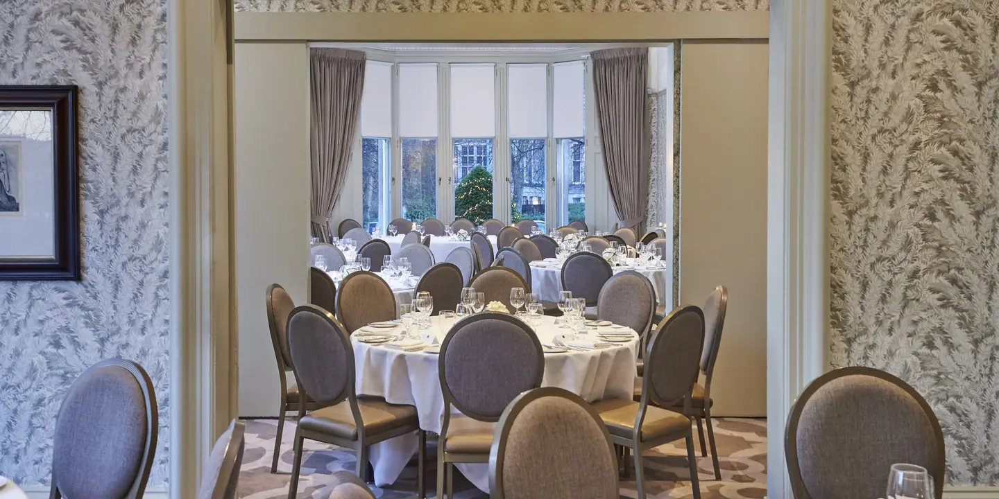 Spacious room with multiple, sophisticated decorated round tables 