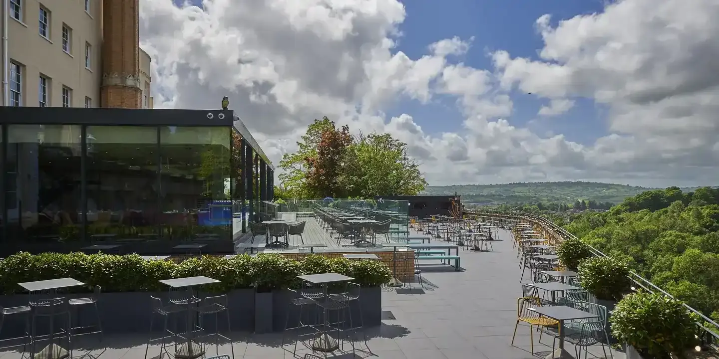 A rooftop terrace featuring tables and chairs.