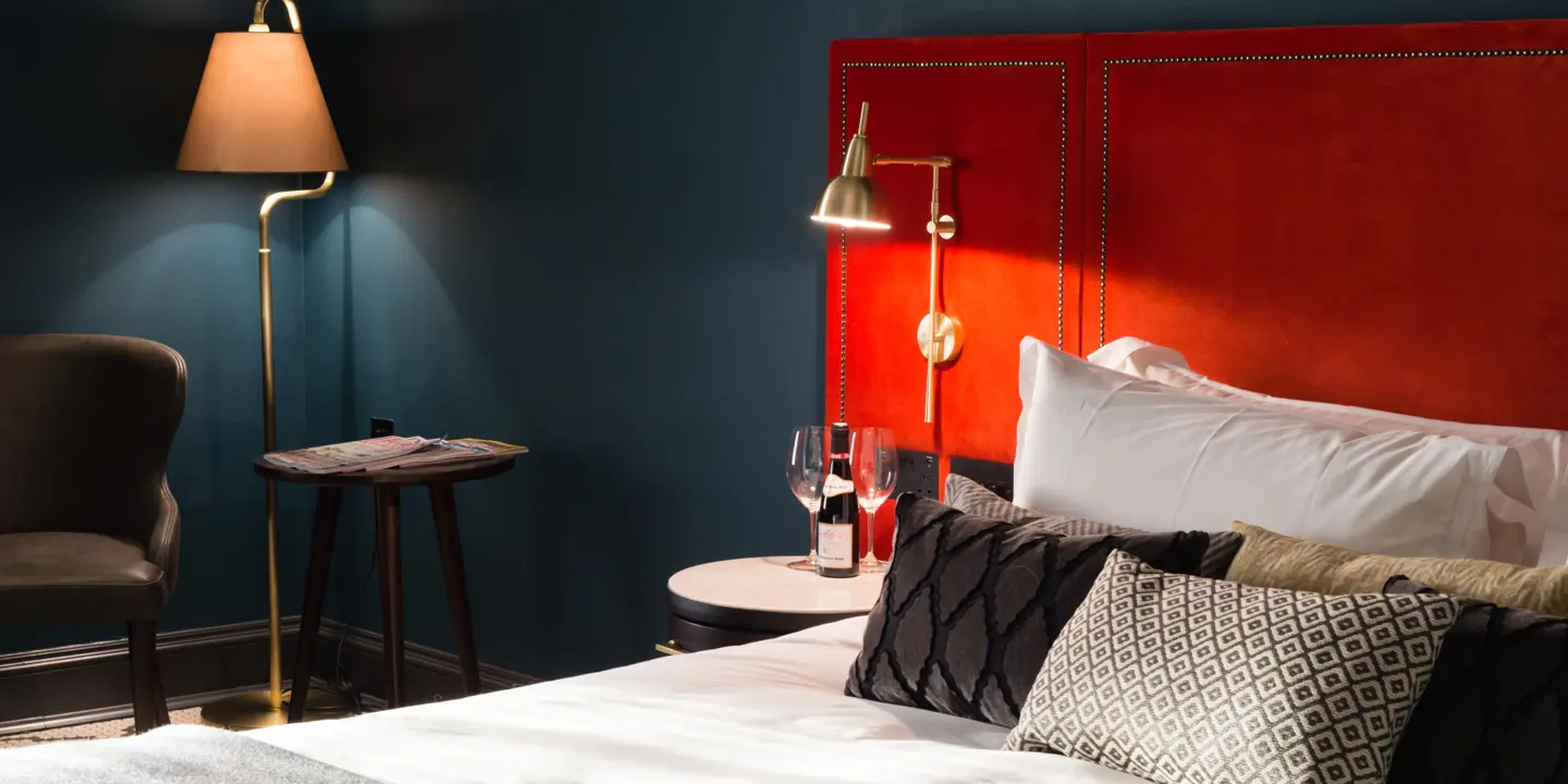 Red headboard and pillows on a bed.