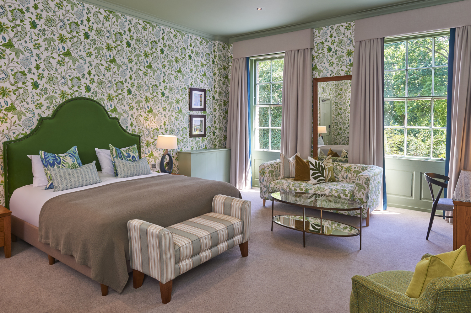 Bedroom featuring a comfortable bed, chairs, and a window.