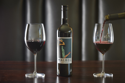 A bottle of Malbec between two full wine glasses