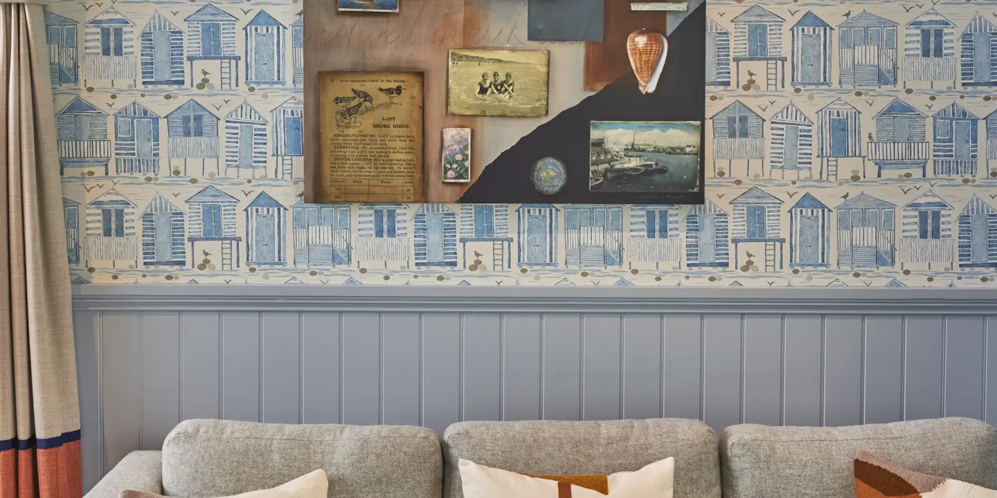 A sofa positioned in front of a wall adorned with photographs.