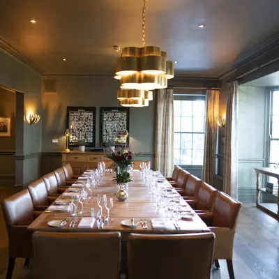 A generously spcaed dining room featuring a long table and chairs.