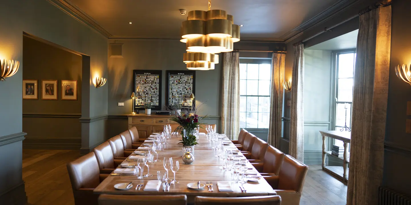 A generously spcaed dining room featuring a long table and chairs.