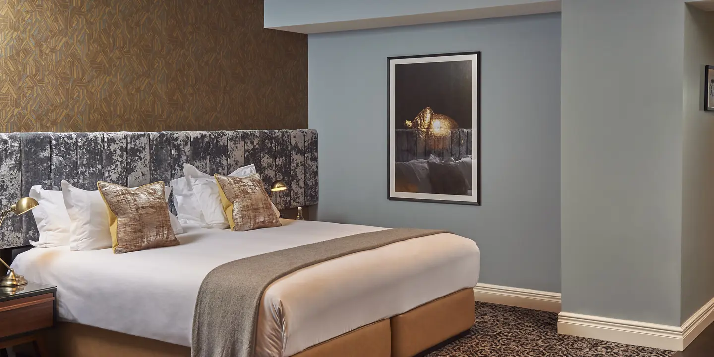 Spacious bedroom featuring a king-sized bed and an art piece adorning the wall.