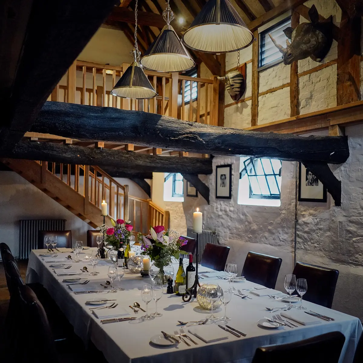 A dining room featuring a beautifully arranged table adorned with elegant wine glasses and flickering candles