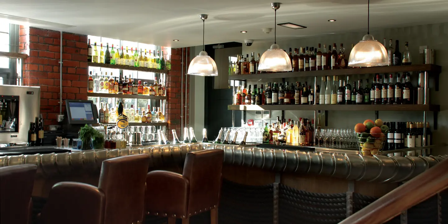 An assortment of bottles displayed on shelves in a bar.