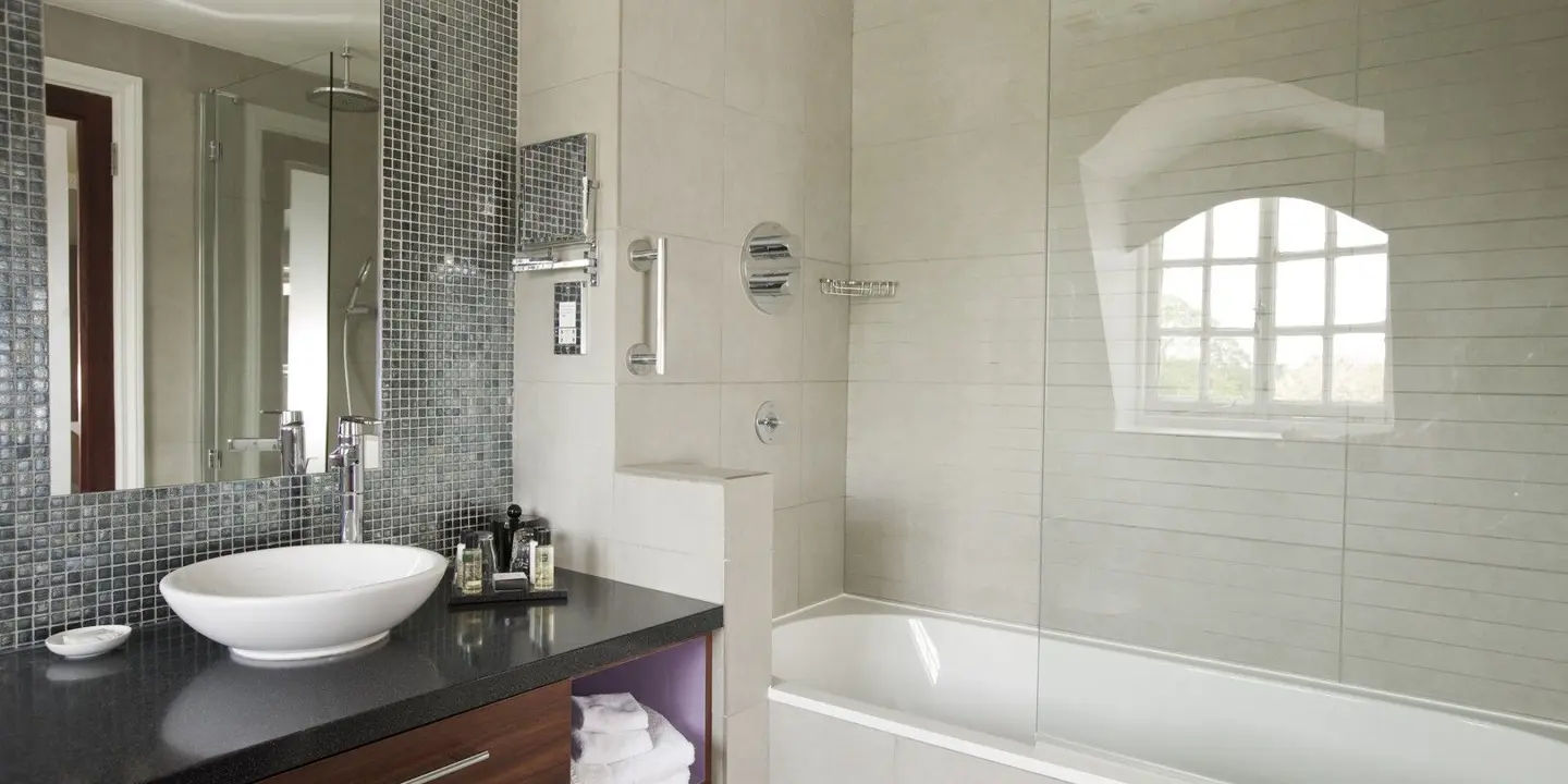 A bathroom featuring a sink, bathtub, and mirror.